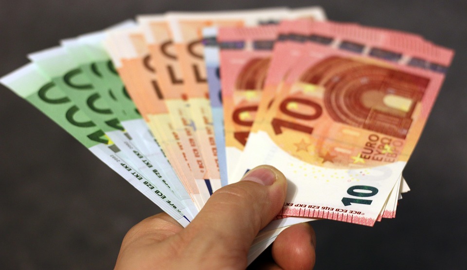 hand met euro biljetten, deze man heeft per week 30 euro bespaart door onze 25 tips om geld te besparen