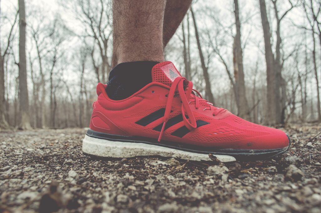 man met schoenen in het bos, Wil je besparen op kleding en schoenen? Ontdek 15 slimme bespaartips, van outletwinkels tot tweedehands mode en duurzaam shoppen. Lees alle praktische tips!